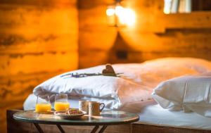 a table with two glasses of orange juice on a bed at Ledro Mountain Chalet in Ledro
