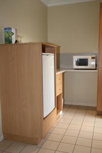 een keuken met een witte koelkast en een magnetron bij Country Roads Motor Inn Gayndah in Gayndah