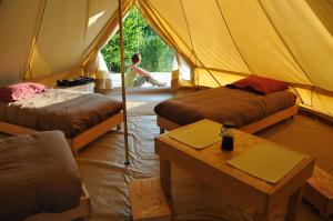 a tent with two beds and a table in it at Ecodomaine Chemins de Traverse in Auberive