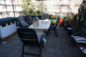 stół i krzesła na patio z parasolem w obiekcie Amsterdam Roof Terrace B&B w Amsterdamie