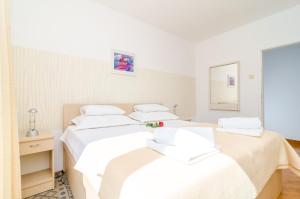 two beds in a room with white sheets at Apartment Bonaca in Dubrovnik