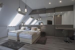 um quarto com 2 camas e um espelho grande em Hotel Talizmán em Kecskemét