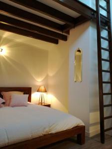 1 dormitorio con 1 cama con escalera y lámpara en Gite du " bas du cru " en Romery