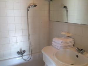 a bathroom with a sink and a shower with towels at Logies De Wandelaar in Westende-Bad