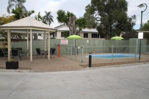 een zwembad met een prieel en een zwembad bij Country Roads Motor Inn Gayndah in Gayndah