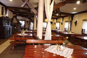 a dining room with wooden tables and chairs at Gościniec Legenda in Wyszogród