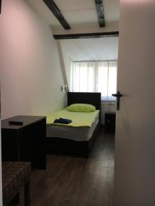 a bedroom with a bed and a table and a window at Pension Haus Baron 2 Friedrichsfeld in Edingen-Neckarhausen