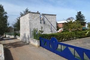 ein blauer Zaun vor einem Gebäude in der Unterkunft Uacella in Locorotondo