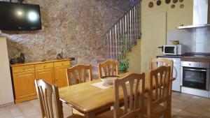 cocina con mesa de madera y sillas y cocina con escalera en Casa Llebra II, en Roquetes