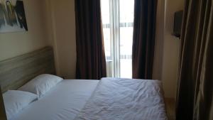 uma cama num quarto de hotel com uma janela em SunAnatolia Otel em Antalya