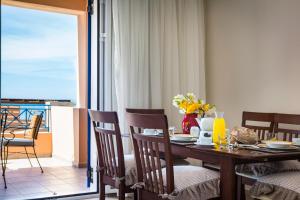 a dining room with a table and chairs and a balcony at Villas Cape in Minia