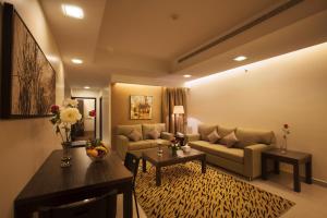 a living room with a couch and a table at Watheer Hotel Suite in Dammam