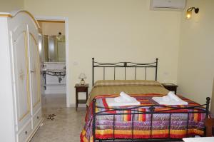 a bedroom with a bed and a bathroom with a sink at Residenza Mosco in Tuglie