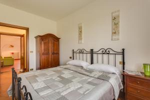 a bedroom with a large bed and a wooden dresser at Country House Podere Le Rane Felici in Fauglia