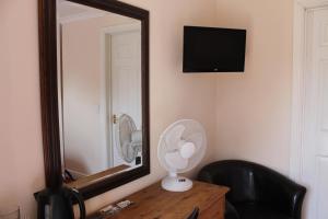 een kamer met een spiegel en een ventilator op een dressoir bij Blatches Farm in Great Dunmow