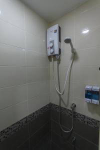 a shower in a bathroom with a soap dispenser at Q Space Residence in Bangkok