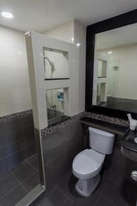 uma casa de banho com um WC, um chuveiro e um espelho. em Q Space Residence em Bangkok