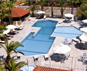 an overhead view of a swimming pool with umbrellas and chairs at Klonos Anna in Egina