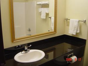 a bathroom with a sink and a mirror and towels at Hometown Inn & Suites in Schererville