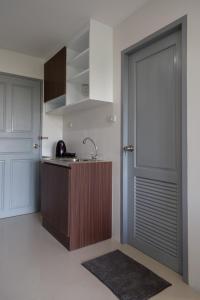 a kitchen with a door and a sink and a counter at Q Space Residence in Bangkok