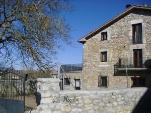 un edificio de piedra con una valla delante en La Nogala, en Dobro