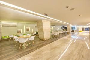 a dining room with tables and chairs in a building at Attide Hotel in Bangalore