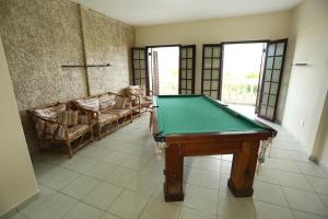 - un salon avec une table de billard et des chaises dans l'établissement Arco Íris Pousada, à Ilha Comprida