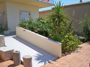 a garden with a white wall and some plants at Klonos Anna in Egina