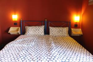 a bedroom with a bed with two lights on the wall at CasaTua Punta Secca in Punta Secca