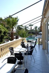 an outdoor patio with tables and chairs and a pool at Klonos Anna in Egina
