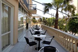 a row of tables and chairs on a balcony at Klonos Anna in Egina