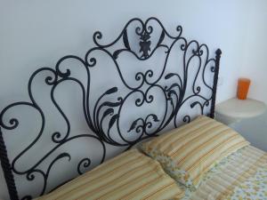 un letto con testiera in bianco e nero di "Pozzo della Corte" - un Raffinato Nido d'Amore Salentino a Sannicola