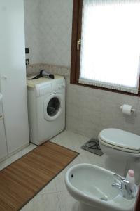 een badkamer met een wasmachine en een toilet bij Corte Graziella in Castel d'Azzano