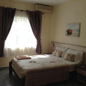 a bedroom with a large bed with a window at Le Palmier C10 in Flic-en-Flac +18 photos