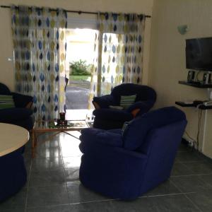 a living room with two chairs and a table at Le Palmier C10 in Flic-en-Flac