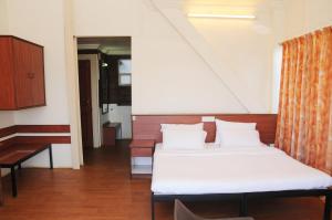 sypialnia z 2 łóżkami z białą pościelą i oknem w obiekcie Wind Chalet w mieście Koynanagar