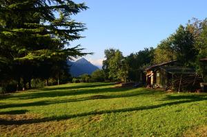 un campo de hierba con una casa y una montaña en La Casina Idro, en Crone