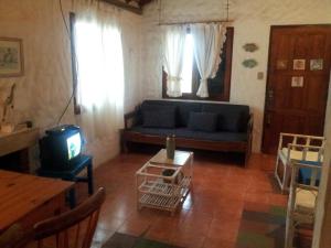 a living room with a blue couch and a tv at Casa Benjaim in Punta Del Diablo