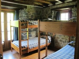two bunk beds in a room with a stone wall at Albergue Turístico Valdebaró in Camaleño +24 photos