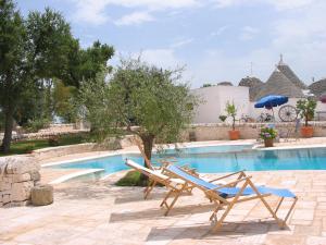 a couple of lounge chairs next to a swimming pool at Masseria Serio in Locorotondo
