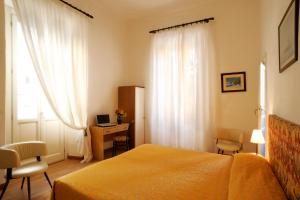 a bedroom with a bed and a desk with a computer at Hotel Alfieri in Alassio +25 photos