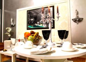 un tavolo bianco con un cesto di frutta e candele di Barberini Dream a Roma