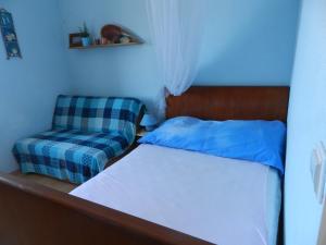 a bedroom with a bed and a chair at Apartment Eli in Lumbarda