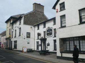 a man walking down a street in front of a building at Boutique Ensuite Studios in Aberystwyth