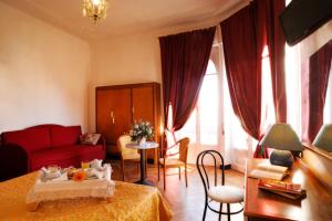 sala de estar con sofá rojo y mesa en Hotel Alfieri, en Alassio