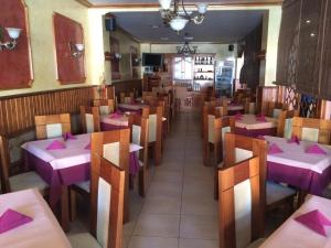 una sala da pranzo con tavoli, sedie e tovaglioli rosa di Hostal Restaurante Grela a Pozo Alcón