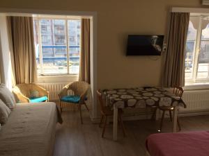 a hotel room with a table and a tv on the wall at Logies De Wandelaar in Middelkerke