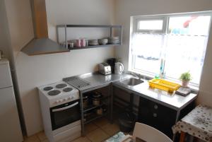 una piccola cucina con piano cottura e lavandino di Grundarfjördur Hostel a Grundarfjordur Altre 18 foto