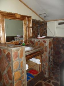 a bathroom with a stone sink and a mirror at Lake Bunyonyi Rock Resort in Kabale