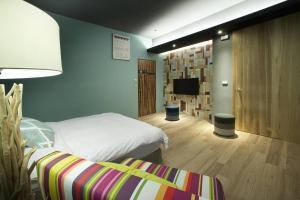 pokój hotelowy z łóżkiem i telewizorem w obiekcie Spring Tree w mieście Luodong
